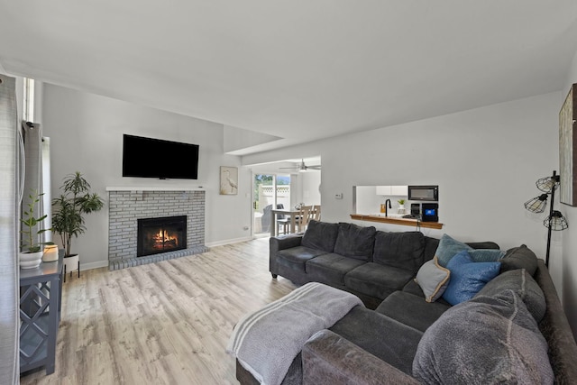 16026 85th Pl, Tinley Park, IL 60487 - living room featuring light wood-type flooring, a brick fireplace, and a ceiling fan