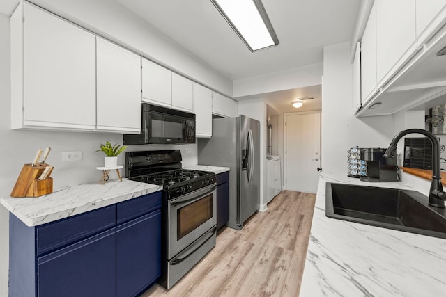 16026 85th Pl, Tinley Park, IL 60487 - kitchen with stainless steel appliances, blue cabinetry, white cabinets, light wood finished floors, and separate washer and dryer