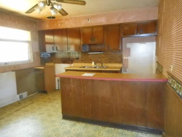 219 N Wilke Rd, Arlington Heights, IL 60005 - kitchen with brown cabinets, ceiling fan, decorative backsplash, and ventilation hood