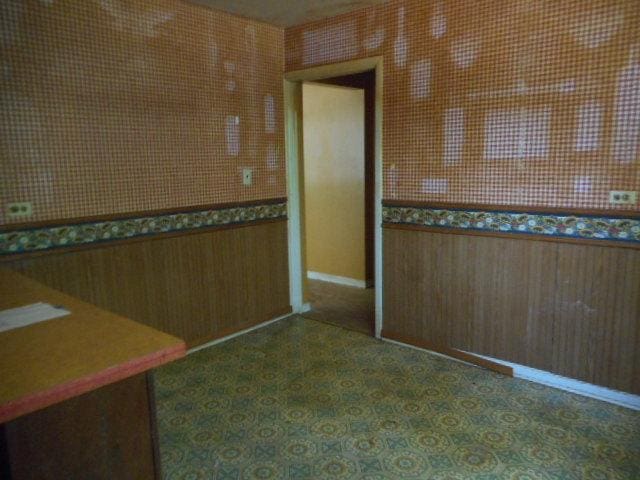 219 N Wilke Rd, Arlington Heights, IL 60005 - unfurnished dining area featuring wooden walls and a wainscoted wall