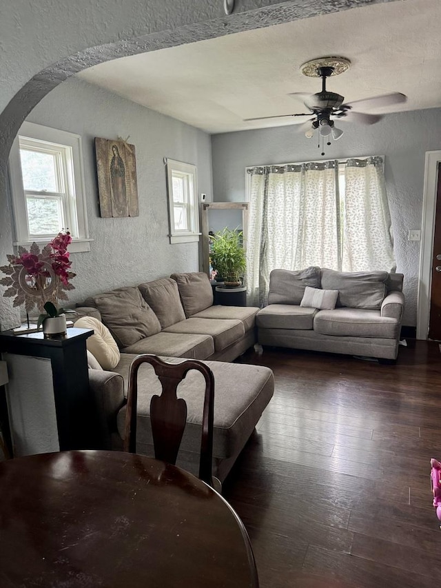 109 Seminary Ave, Aurora, IL 60505 - living room featuring a textured wall, arched walkways, plenty of natural light, a ceiling fan, and dark wood finished floors