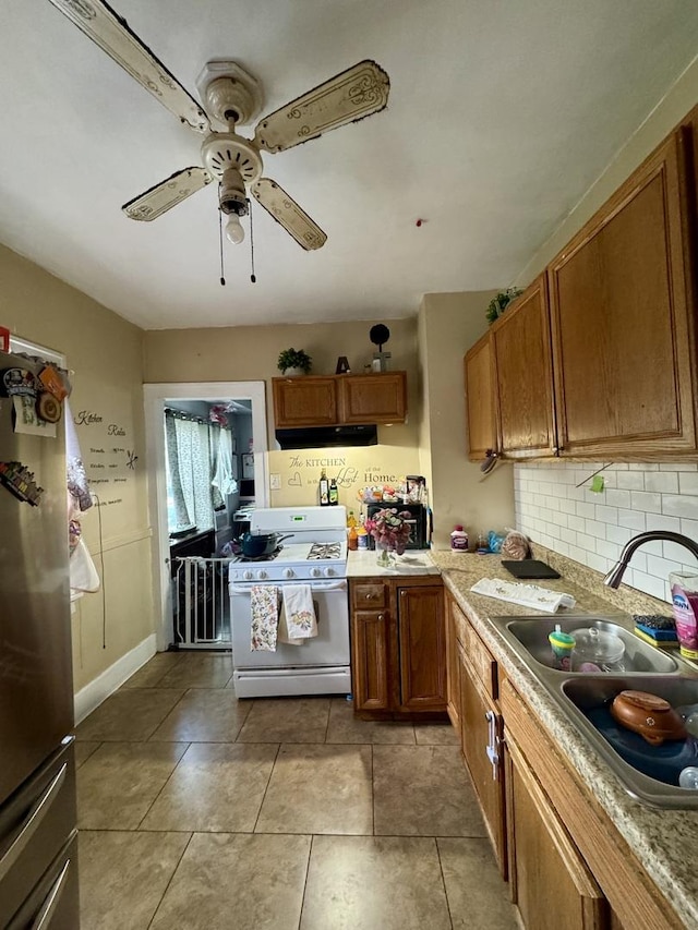 109 Seminary Ave, Aurora, IL 60505 - kitchen with white gas range oven, under cabinet range hood, fridge, brown cabinetry, and light countertops