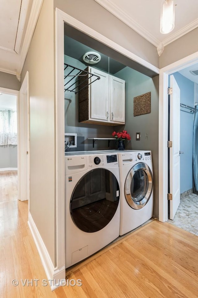 806 S May St, Chicago, IL 60607 - laundry area featuring ornamental molding, light wood-type flooring, cabinet space, washer and clothes dryer, and attic access