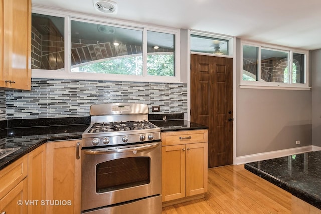 806 S May St, Chicago, IL 60607 - kitchen with stainless steel range with gas cooktop, light wood finished floors, dark stone counters, and decorative backsplash