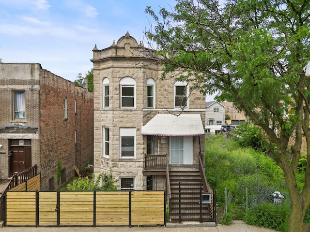 1532 S Homan Ave, Chicago, IL 60623 - view of front of house with stone siding, a fenced front yard, stairway, and cooling unit