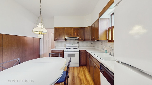 3120 N Natoma Ave, Chicago, IL 60634 - kitchen featuring white appliances, light wood-style floors, light countertops, hanging light fixtures, and under cabinet range hood