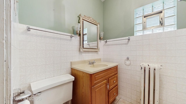 3120 N Natoma Ave, Chicago, IL 60634 - bathroom featuring radiator, tile walls, vanity, and wainscoting