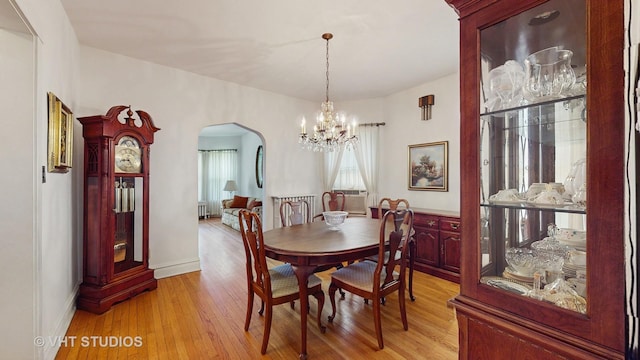 3120 N Natoma Ave, Chicago, IL 60634 - dining room with arched walkways, a chandelier, and light wood finished floors