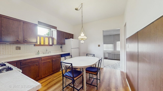 3120 N Natoma Ave, Chicago, IL 60634 - kitchen featuring radiator heating unit, freestanding refrigerator, light wood-style floors, and decorative light fixtures