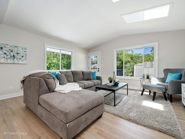 622 Pleasant Pl, Streamwood, IL 60107 - living area featuring a skylight, lofted ceiling, and light wood-style floors