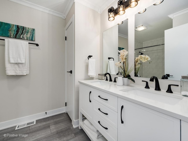 622 Pleasant Pl, Streamwood, IL 60107 - full bathroom featuring crown molding, double vanity, wood finished floors, and tiled shower