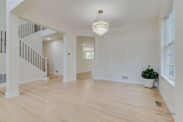 5860 Betty Gloyd Dr, Hoffman Estates, IL 60192 - unfurnished room with wood finished floors, a chandelier, and stairway