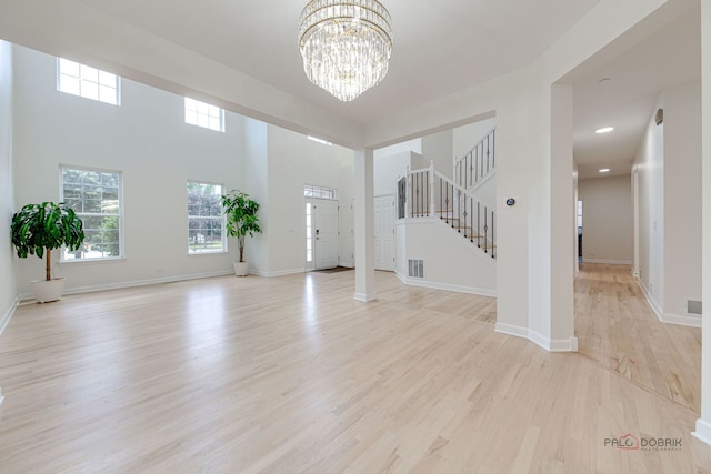 5860 Betty Gloyd Dr, Hoffman Estates, IL 60192 - unfurnished living room with a chandelier, light wood-style floors, plenty of natural light, and stairs