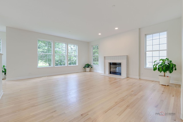 5860 Betty Gloyd Dr, Hoffman Estates, IL 60192 - unfurnished living room with light wood-type flooring, a glass covered fireplace, plenty of natural light, and recessed lighting