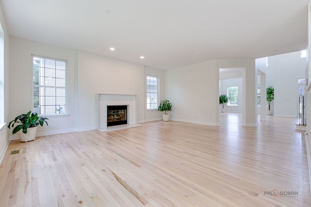 5860 Betty Gloyd Dr, Hoffman Estates, IL 60192 - unfurnished living room with light wood-type flooring, healthy amount of natural light, a fireplace with raised hearth, and recessed lighting
