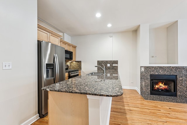 1917 S State St Unit 1, Chicago, IL 60616 - kitchen with stainless steel appliances, light wood-style flooring, a peninsula, a high end fireplace, and light brown cabinetry