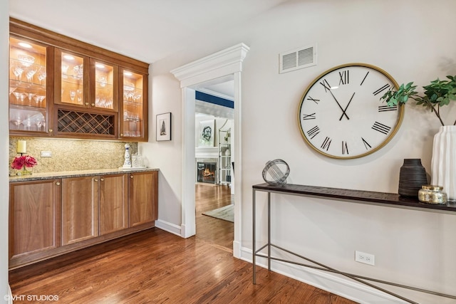 423 S Beverly Ln, Arlington Heights, IL 60005 - bar featuring dark wood-style flooring, decorative backsplash, and a glass covered fireplace