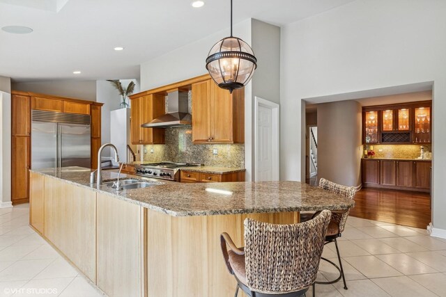 423 S Beverly Ln, Arlington Heights, IL 60005 - kitchen featuring wall chimney exhaust hood, stainless steel built in refrigerator, light tile patterned floors, tasteful backsplash, and stone counters