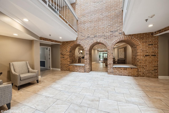 601 Lake Hinsdale Dr Unit 104, Willowbrook, IL 60527 - lobby featuring a high ceiling, brick wall, and recessed lighting