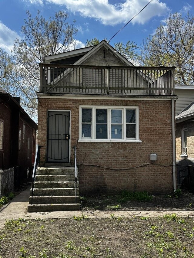 7621 S Eberhart Ave, Chicago, IL 60619 - view of front facade featuring a balcony, entry steps, and brick siding
