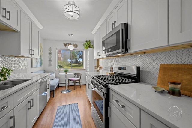 1321 S Finley Rd Unit 108, Lombard, IL 60148 - kitchen with stainless steel appliances, a baseboard radiator, decorative backsplash, and white cabinets