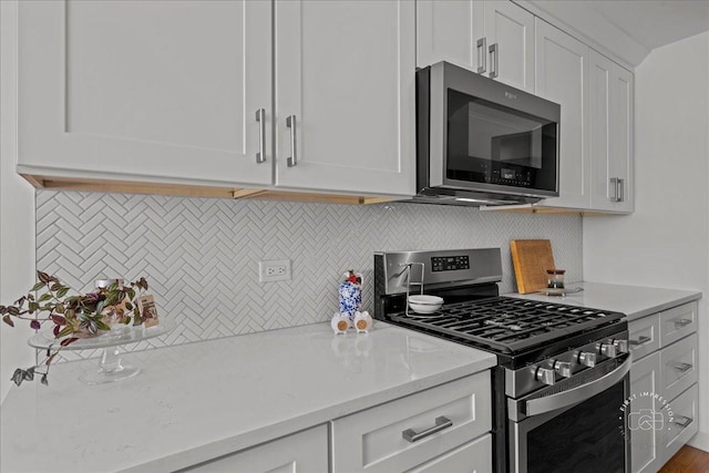 1321 S Finley Rd Unit 108, Lombard, IL 60148 - kitchen with appliances with stainless steel finishes, tasteful backsplash, white cabinets, and light stone counters