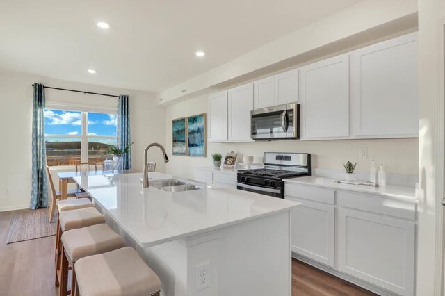 3708 Stockton Dr, Joliet, IL 60436 - kitchen featuring appliances with stainless steel finishes, a kitchen island with sink, white cabinetry, recessed lighting, and light wood-type flooring