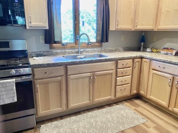 29176 Terra Vista Dr, Rock Falls, IL 61071 - kitchen with gas stove, black microwave, light wood-type flooring, and light stone counters