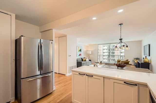 6007 N Sheridan Rd Unit 36F, Chicago, IL 60660 - kitchen featuring freestanding refrigerator, open floor plan, hanging light fixtures, light wood-style floors, and white cabinetry