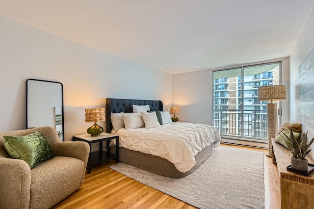 6007 N Sheridan Rd Unit 36F, Chicago, IL 60660 - bedroom featuring a baseboard radiator, wood finished floors, and access to outside