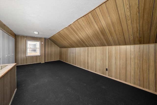 12216 S Carpenter St, Chicago, IL 60643 - bonus room featuring wooden walls, lofted ceiling, a textured ceiling, and dark carpet