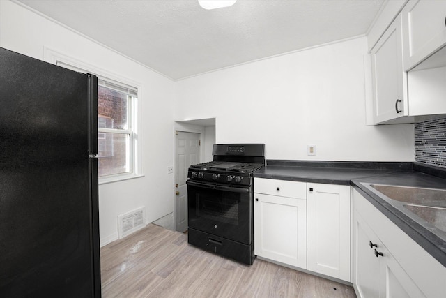 12216 S Carpenter St, Chicago, IL 60643 - kitchen featuring black appliances, light wood-style floors, dark countertops, and white cabinetry