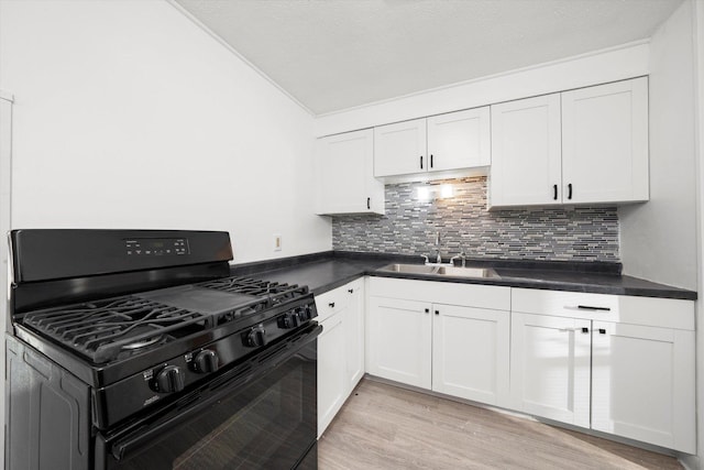 12216 S Carpenter St, Chicago, IL 60643 - kitchen featuring black gas range, dark countertops, tasteful backsplash, light wood finished floors, and white cabinetry