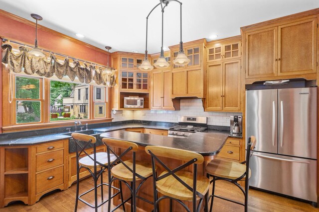 311 Nicholson St, Joliet, IL 60435 - kitchen with light wood finished floors, a breakfast bar area, glass insert cabinets, a center island, and crown molding