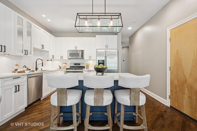 2259 W Wabansia Ave Unit 309, Chicago, IL 60647 - kitchen with appliances with stainless steel finishes, decorative backsplash, a kitchen bar, a kitchen island, and recessed lighting