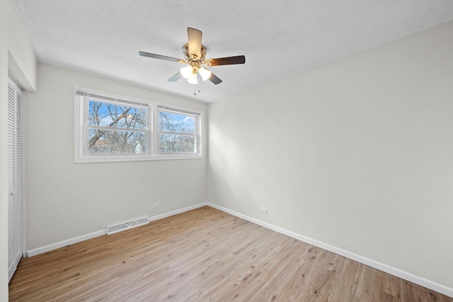 3508 Maple Ln, Hazel Crest, IL 60429 - unfurnished bedroom with a closet, light wood-style flooring, a textured ceiling, and ceiling fan