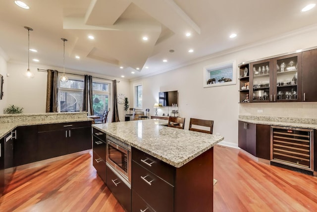 2011 W Huron St, Chicago, IL 60612 - kitchen with wine cooler, stainless steel microwave, ornamental molding, light wood finished floors, and modern cabinets