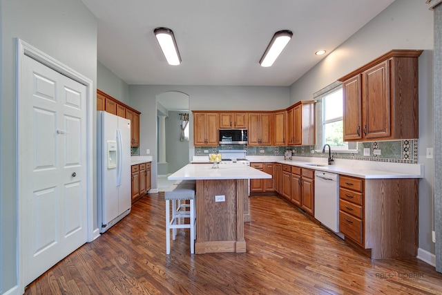 2208 Sanctuary Ct, Gurnee, IL 60031 - kitchen with white appliances, dark wood-type flooring, a breakfast bar, and a center island