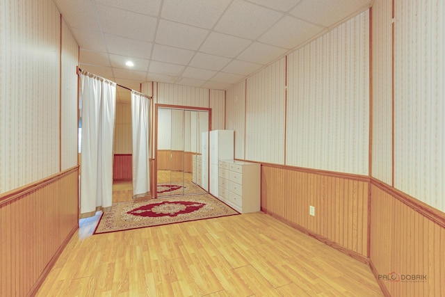 2208 Sanctuary Ct, Gurnee, IL 60031 - empty room featuring wood finished floors, wallpapered walls, a wainscoted wall, and a drop ceiling