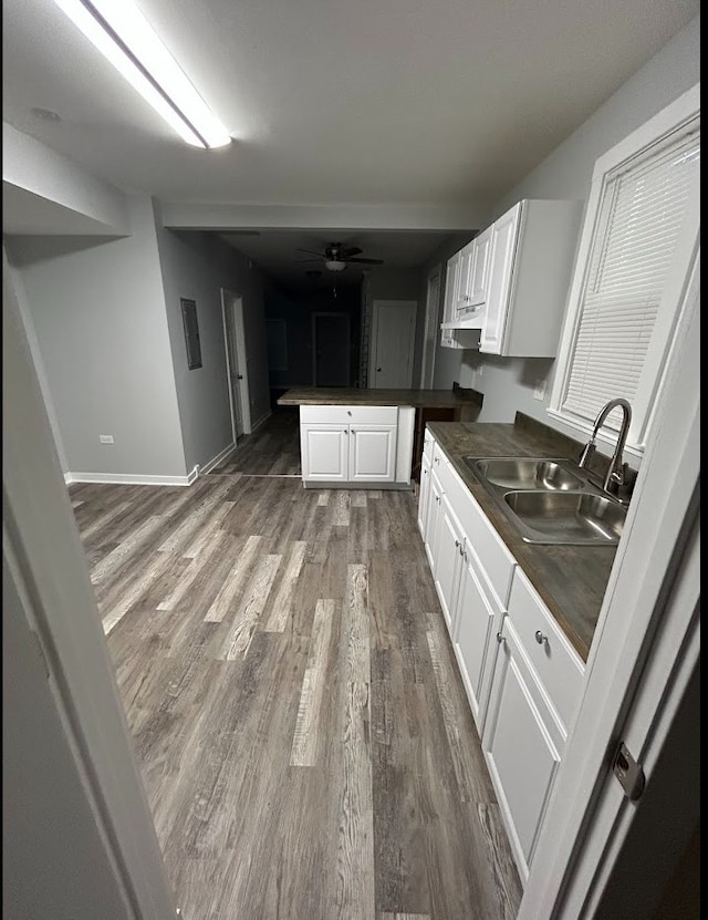 4936 W Harrison St, Chicago, IL 60644 - kitchen with dark countertops, a peninsula, wood finished floors, white cabinetry, and a ceiling fan