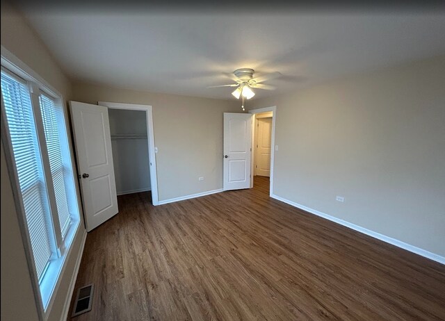 4936 W Harrison St, Chicago, IL 60644 - unfurnished bedroom with dark wood-type flooring, a spacious closet, and ceiling fan