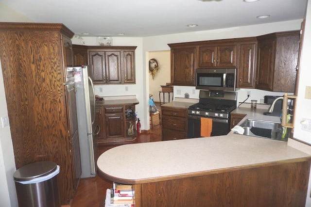4914 W State Route 113, Kankakee, IL 60901 - kitchen featuring appliances with stainless steel finishes, a peninsula, dark wood-style floors, recessed lighting, and dark brown cabinetry