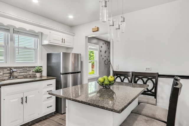 308 Dalton Ave, Mundelein, IL 60060 - kitchen featuring freestanding refrigerator, a breakfast bar area, backsplash, white cabinetry, and dark stone countertops