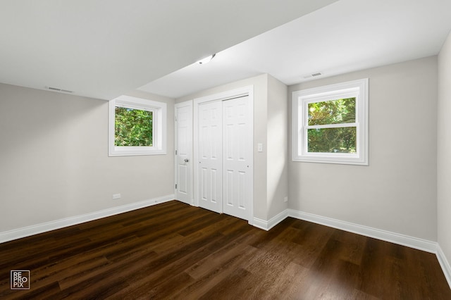 19228 W Quail Ct, Elwood, IL 60421 - unfurnished bedroom featuring dark wood-style floors, multiple windows, and a closet