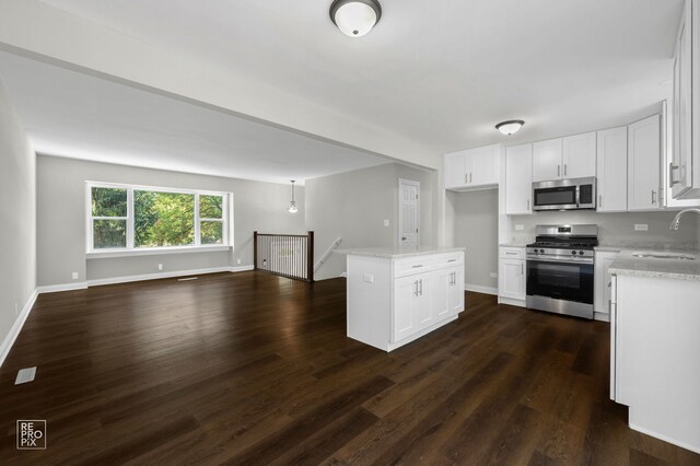 19228 W Quail Ct, Elwood, IL 60421 - kitchen featuring appliances with stainless steel finishes, open floor plan, dark wood-style flooring, and white cabinetry