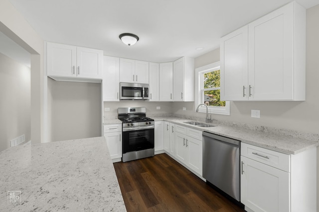19228 W Quail Ct, Elwood, IL 60421 - kitchen with stainless steel appliances, dark wood-style flooring, light stone counters, and white cabinetry