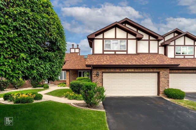 8909 Silverdale Dr Unit 5C, Orland Park, IL 60462 - tudor house featuring an attached garage, asphalt driveway, a front lawn, and brick siding