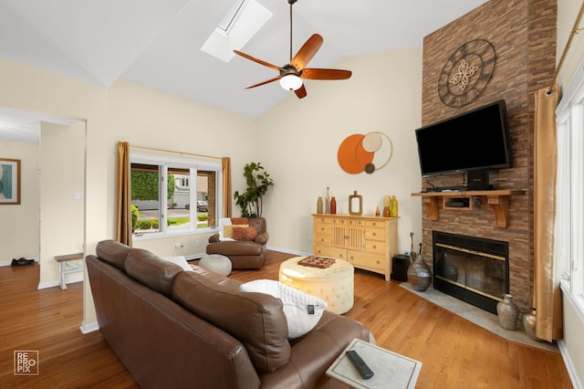 8909 Silverdale Dr Unit 5C, Orland Park, IL 60462 - living area featuring a fireplace, ceiling fan, wood finished floors, high vaulted ceiling, and a skylight