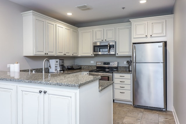601 Lake Hinsdale Dr Unit 209, Willowbrook, IL 60527 - kitchen featuring appliances with stainless steel finishes, a peninsula, dark stone countertops, recessed lighting, and light stone finish flooring