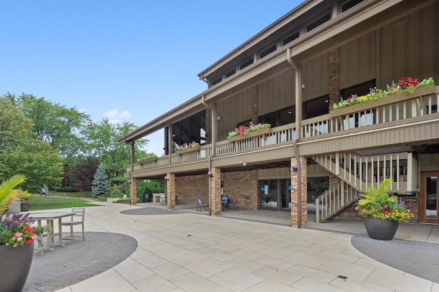 601 Lake Hinsdale Dr Unit 209, Willowbrook, IL 60527 - rear view of property featuring a patio, board and batten siding, and brick siding